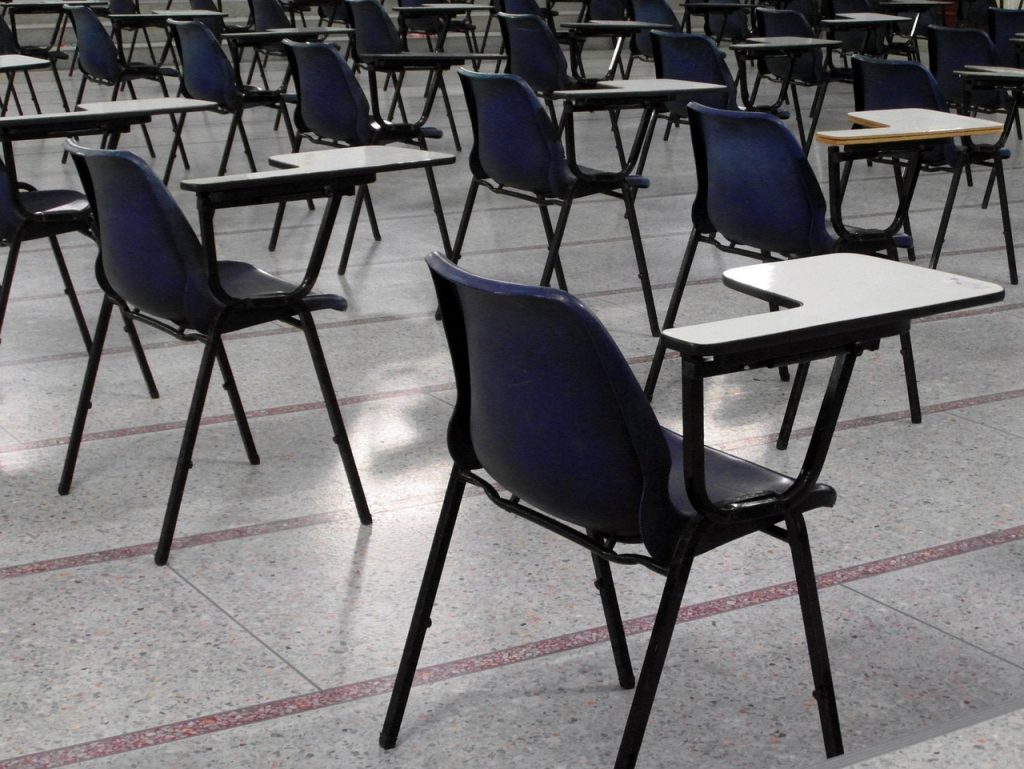 Empty exam hall with rows of desks