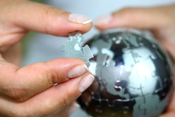 a person holding a globe made of jigsaw pieces to signify small individual pieces of learning