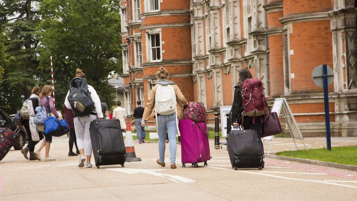 students arriving at a university with suitcases